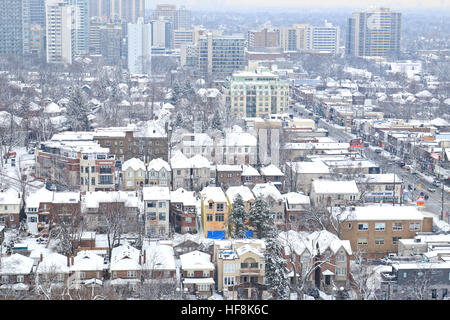 Toronto, Kanada. 29. Dezember 2016. Städtische Wohnhäuser, Wohnung und Eigentumswohnung Gebäude mit nassen Neuschnee in Midtown Mount Pleasant Road und Eglinton Avenue Road West Bereich. Verkehr und die Leute ziehen langsam auf Mount Pleasant Road auf der rechten Seite. © CharlineXia/Alamy Live-Nachrichten Stockfoto