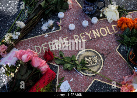 Los Angeles, USA. 29. Dezember 2016. Blumen und Kerzen umgeben den Hollywood Walk of Fame Stern von Debbie Reynolds, in Los Angeles, Kalifornien, USA, am 29. Dezember 2016. Hollywood-Star Debbie Reynolds von Schlaganfällen starb am Mittwoch im Alter von 84, einen Tag nach dem Tod ihrer Tochter Carrie Fisher. Carrie Fisher, die Schauspielerin am bekanntesten als Prinzessin Leia in der "Star Wars"-Film-Franchise, starb im Alter von 60 Jahren am Dienstagmorgen nach einem Herzinfarkt auf einen Flug am vergangenen Freitag. © Zhao Hanrong/Xinhua/Alamy Live-Nachrichten Stockfoto