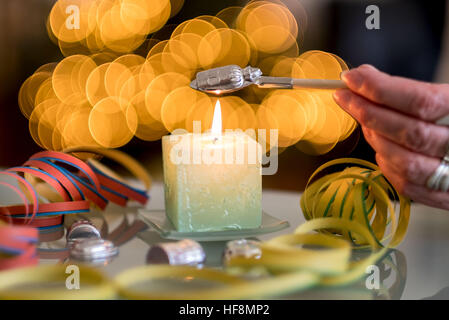 Hannover, Deutschland. 29. Dezember 2016. ILLUSTRATION - ein Stück Blei Schmelze über eine Kerze in Hannover, 29. Dezember 2016 wird. Molybdomancy - Blei Gießen - ist eine beliebte Tradition in Europa. Kleine Stücke von Blei sind auf einem Löffel über einer Kerze geschmolzen und dann in Wasser, neugierige und bizarre Formen, die an das kommende Jahr vorhersagen sollen gegossen. Foto: Peter Steffen/Dpa/Alamy Live News Stockfoto