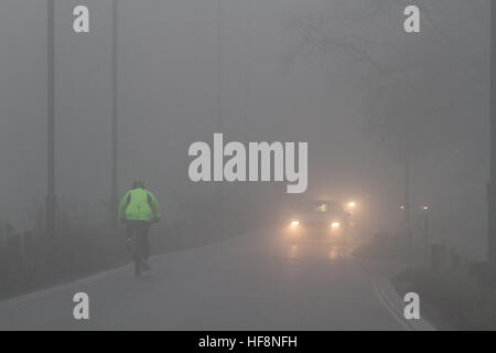 Wimbledon London, UK. 30. Dezember 2016. Ein Radfahrer und Autofahrer fahren durch dichten eiskalten Nebel in Wimbledon © Amer Ghazzal/Alamy Live-Nachrichten Stockfoto