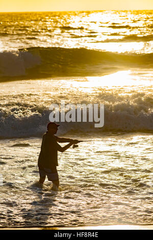 Ein Mann, der früh an einem Sommermorgen an einem Sydney Strand Angeln Stockfoto