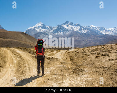 Einsame Wanderer auf einer Kreuzung zweier Straßen in Richtung Berge. Stockfoto