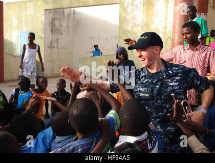 U.S. Navy Musiker 2. Klasse Justin Strauss, der US Naval Forces Europe Band? Fünf Sterne Blechbläserquintett? High-Fives Kindern nach einem Auftritt bei der Colin Powell Cultural Center in Dakar, Senegal, 8. April 2010. Die Band ist an Bord der amphibischen Dock Landungsschiff USS Gunston Hall (LSD 44) als Teil von West Afrika Partnerschaft Station (APS) in Angriff genommen. APS ist eine internationale Initiative von US Naval Forces Europe/Africa entwickelt zur Verbesserung der Sicherheit im Seeverkehr und Sicherheit auf dem afrikanischen Kontinent. (Foto: DoD Mass Communication Specialist 1. Klasse Gary Keen, US Navy/freigegeben) 100408-N - Stockfoto