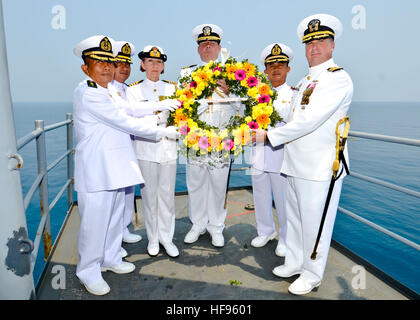 Marineoffiziere aus Australien, Indonesien und den USA beteiligen sich an einer Kranzniederlegung an Bord der zarten USS Frank Seekabel (AS 40) zu Ehren von den Besatzungen der US Navy schwere Kreuzer USS Houston (CA-30) und der Royal Australian Navy-Kreuzer HMAS Perth (D29). Beide Schiffe wurden während der Schlacht von Sunda-Straße im Februar 1942 während des zweiten Weltkriegs durch Imperiale japanische Truppen in indonesischen Gewässern versenkt.  Frank Cable, nach vorn auf der Insel Guam bereitgestellt führt Wartungs- und u-Boote und Überwasserschiffe eingesetzt, um den USA 7. Flotte Bereichen SGU Stockfoto