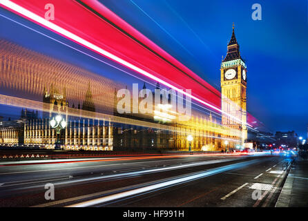 Big Ben, eines der bekanntesten Wahrzeichen von London und England, wie in der Nacht zusammen mit den Lichtern der vorbeifahrende Autos gezeigt Stockfoto