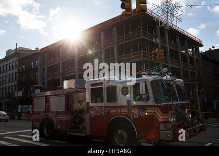 Ein New Yorker Feuerwehr Truck lässt sich von einem neu erbauten Wohnhaus auf der Atlantic Avenue in Brooklyn, New York. Stockfoto