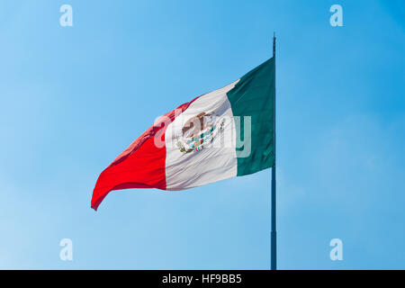 Flagge von Mexiko im Wind an einem sonnigen Tag gegen den blauen Himmel. Stockfoto