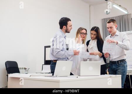 Gruppe von vier verschiedenen Männern und Frauen in Freizeitkleidung im Gespräch im Büro Stockfoto