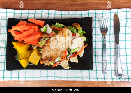 Gegrilltes Hühnersteak mit Gewürzen und Gemüse auf die schwarze Schale, gesunde Ernährung Mahlzeiten. Stockfoto