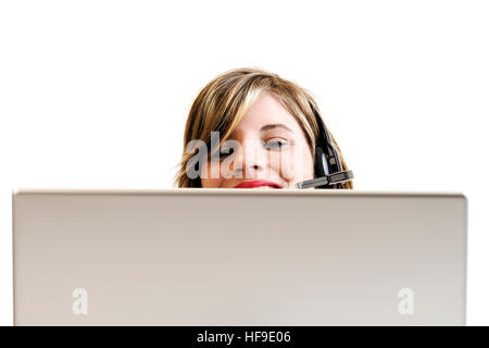 Junge Frau trägt Kopfhörer sitzen vor Laptop: Call-Center Stockfoto