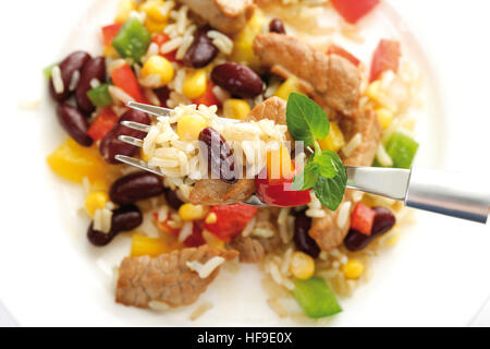 Reisgericht mit Schweinefleisch, Paprika, Kidney-Bohnen, Mais und Langkornreis, Essen auf die Gabel, aus der Vogelperspektive Stockfoto