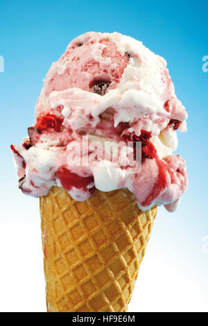 Zwei Kugeln Erdbeer und Kirsche gefrorenen Joghurt in einem Waffelhörnchen Stockfoto