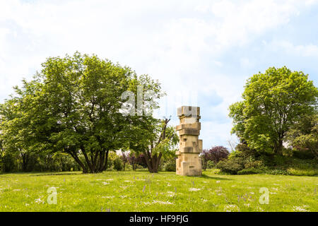 Blick auf Donaupark mit grünem Rasen, Bäume und Steinstatue, Wien, Österreich Stockfoto