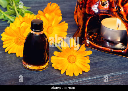 Calendula-Öl in eine Flasche aus Glas auf einem hölzernen Hintergrund. Vintage-straff-Effekt Stockfoto