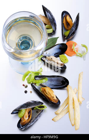 Holländische Spezialität: Muscheln mit Pommes Frites und einem Glas Weißwein Stockfoto
