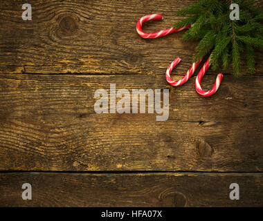 Weihnachtsbaum-Zweige mit Zuckerstangen auf Holz Textur bereit für Ihr Design. Winter Urlaub Hintergrund Stockfoto