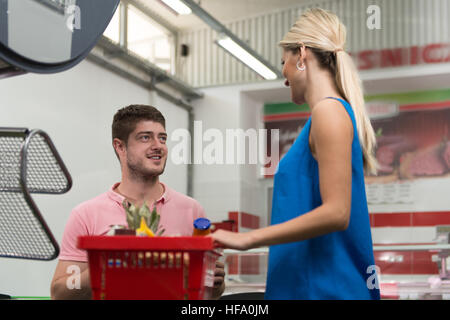 Frau an der Kasse bezahlen mit Kreditkarte im Supermarkt Stockfoto