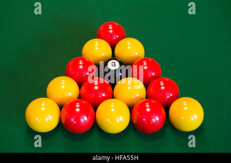 Rote und gelbe Billardkugeln auf dem grünen Tisch. Stockfoto