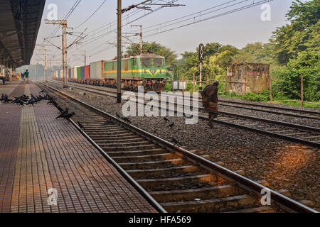 Ein Alter Mann versucht gefährlich, überqueren Sie die Bahngleise vor einem Güterzug an einem nebligen Wintermorgen. Stockfoto