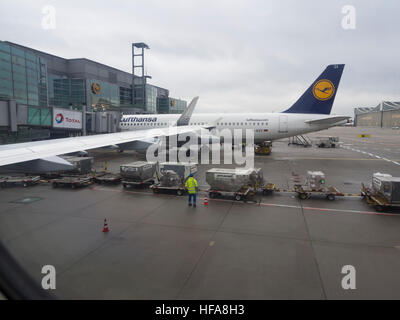 Lufthansa-Maschine angedockt am internationalen Terminal im Flughafen Frankfurt Am Main an einem grauen und nassen Herbsttag Stockfoto