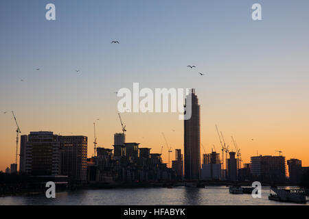 Baukräne Silhouette auf die Skyline von London als die Sonne untergeht. Stockfoto