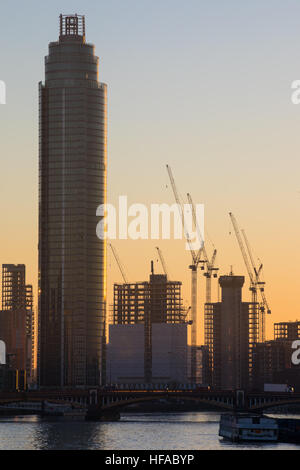 Baukräne Silhouette auf die Skyline von London als die Sonne untergeht. Stockfoto