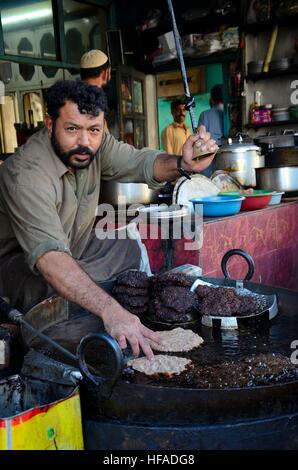 Mann bereitet und Pommes frites pakistanischen Chapli Kebab Fleischgericht in Öl Pfanne beim Läuten der Glocke Gilgit Pakistan Stockfoto