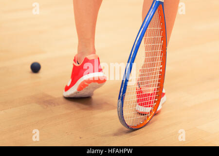 Eine junge weibliche Squashspieler den Ball in einen Squash-court Stockfoto