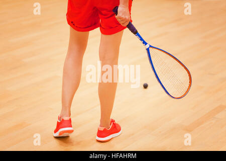 Eine junge weibliche Squashspieler den Ball in einen Squash-court Stockfoto