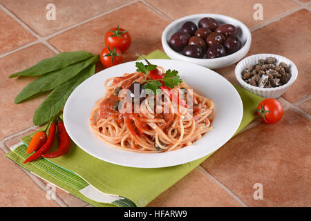 Spaghetti Puttanesca - traditionellem italienischen Rezept mit Sardellen, Kapern, Tomaten und Chili Stockfoto