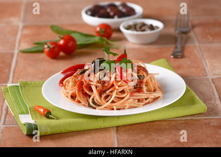 Spaghetti Puttanesca - traditionellem italienischen Rezept mit Sardellen, Kapern, Tomaten und Chili Stockfoto