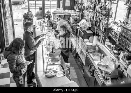 Eine Tapas-Café in Barcelona ist geschäftigen und belebten am Morgen als Mann Aufträge Jamon Croissant heiße Schokolade von einem katalanischen Mann Stockfoto