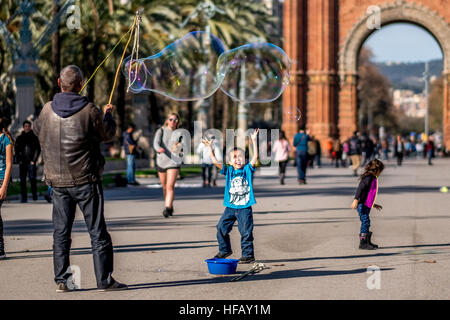 Ein Mann macht riesige Seifenblasen in einem Park in Spanien. Stockfoto