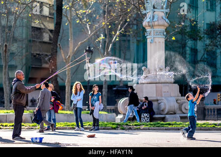 Ein Mann macht riesige Seifenblasen in einem Park in Spanien. Stockfoto