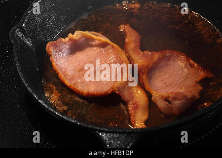 Speck in einer gusseisernen Pfanne Kochen Stockfoto