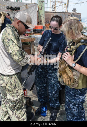 Elektriker Mate 1. Klasse Dante Coppock, zugewiesen, Commander, Task Unit 56.7.4, Coastal Riverine Squadron 4, Delta Company, spricht mit Midshipmen über Waffen in der US Navy während eines Besuchs in den Befehl verwendet. Riverine Schwadronen führen Punkt Verteidigung, feine Unterstützung und Verbot Maßnahmen zur Erhöhung der Sicherheit im Seeverkehr Operationen und Sicherheitsbemühungen Zusammenarbeit Theater in der 5. Flotte Verantwortungsbereich. (Foto: U.S. Navy Mass Communication Specialist 1. Klasse Peter Lewis/freigegeben) Coastal Riverine Squadron 4 130710-N-AZ907-029 Stockfoto