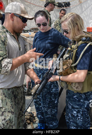 Elektriker Mate 1. Klasse Dante Coppock, zugewiesen, Commander, Task Unit 56.7.4, Coastal Riverine Squadron 4, Delta Company, spricht mit Midshipmen über Waffen in der US Navy während eines Besuchs in den Befehl verwendet. Riverine Schwadronen führen Punkt Verteidigung, feine Unterstützung und Verbot Maßnahmen zur Erhöhung der Sicherheit im Seeverkehr Operationen und Sicherheitsbemühungen Zusammenarbeit Theater in der 5. Flotte Verantwortungsbereich. (Foto: U.S. Navy Mass Communication Specialist 1. Klasse Peter Lewis/freigegeben) Coastal Riverine Squadron 4 130710-N-AZ907-034 Stockfoto