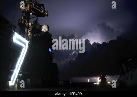 Flight Deck Personalarbeit auf dem Mehrzweck amphibischer Angriff Schiff USS Iwo Jima (LHD-7) Nachteinsätze als es Gewitter in der Ferne. Iwo Jima liegt an der Küste Guatemalas unterstützen humanitäre Hilfsmission der anhaltenden Versprechen 2010. Den zugewiesenen medizinischen und technischen Personal an Bord Iwo Jima begannen Arbeiten mit Partnerteams Nation, Medizin, dental, Veterinär, technische Hilfe zu acht verschiedenen Nationen bieten. Weiterhin Versprechen 2010 318442 Stockfoto