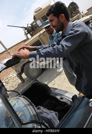 120401-N-VN372-003 KABUL (1. April 2012) Afghan National Police Officer Sahab Shak inspiziert ein Fahrzeug für Drogen, Waffen und andere illegale Materialien bei einer Routine-Checkpoint in nördlichen Kabul als Koalition Berater aus dem Task Force Cujo Standby zu unterstützen.   Task Force Cujo besteht aus 28 Männer und Frauen aus Oregon 1186th Army National Guard Militärpolizeieinheit.   NATO Training Mission-Afghanistan ist ein Zusammenschluss von 38 truppenstellenden Nationen mit der Unterstützung der Regierung der islamischen Republik Afghanistan in eine leistungsfähige und nachhaltige afghanischen nationalen Sicherheit Forc generieren Stockfoto