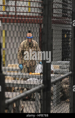 Ein Seemann, der Marine Expeditionary Wachbataillon zugewiesen hilft Entfernung einer Rückhalteeinrichtung für weiche Bein von einem Häftling, wie der Häftling eine Klasse in Joint Task Force Guantanamo beendet. Geschäftsbetrieb der Häftling in Guantanamo 275562 Stockfoto