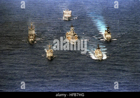 Eine Antenne Bogen Blick auf die erste Schlachtschiff Kampfgruppe in den westlichen Pazifik seit dem Koreakrieg im Gange bereitstellen.  Die Schiffe sind im Uhrzeigersinn von oben: Nachschub Öler USS WABASH (AOR-5), Zerstörer USS MERRILL (DD-976), Fregatte USS GRAY (FF-1054), Lenkflugkörper Fregatte USS THACH (FFG-43), Atom-Lenkflugkörper Kreuzer USS LONG BEACH (CGN-9) und das Schlachtschiff USS NEW JERSEY (BB-62), zentrieren. DN-SC-87-00351-Bow Blick auf Schlachtschiff Kampfgruppe, 1986 Stockfoto