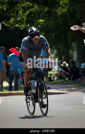 Lt. CMdR Jaime Sigala, der Waffen-Offizier von Naval Special Warfare Unterstützung Logistikeinheit 2, hat Wasser auf ihn von einem freiwilligen gegossen, während die Männer upright Bike-Event bei den 2015 DoD Krieger spielen bei Marine Base Quantico, Virginia, 21. Juni 2015. Die Krieger-Spiele ist eine Jahresveranstaltung des US-Verteidigungsministerium entwickelt, um Verwundete, Kranke und verletzte Soldat innen und Veteranen zu Paralympischen sport Wettbewerb und ermutigen, körperlich aktiv zu bleiben. (Foto: U.S. Navy Mass Communication Specialist 1. Klasse Tony DeFilippo/freigegeben) DoD Krieger Spiele, Heilung durch Spitzenleistungen 150621-N - Stockfoto