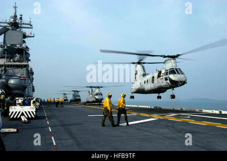 Eine Landung Signal meldete leitet einen CH-46E Hubschrauber, Marine Medium Hubschrauber Geschwader 265 zugewiesen, wie es aus dem Flugdeck der amphibischen Angriff Schiff USS Essex (LHD-2) hebt. Essex und der eingeschifften 31. Marine Expeditionary Unit kamen in Sihanoukville für einen Port-Besuch Matrosen und Marinesoldaten geben die Möglichkeit zur Teilnahme an Gemeinschaftsveranstaltungen Beziehungen Freundschaft-Gebäude, medizinische und zahnmedizinische Projekte und fachlichen Austausch. Essex ist das Typschiff der nur vorwärts bereitgestellt US Expeditionary Strike Group und dient als Flaggschiff für kombiniert Task Force 76, der Marine auf Stockfoto