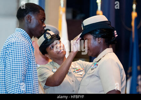 NEWPORT, RI (14. September 2012) Chief Navy Ratgeber Zeporah Dasher hat ihre Kombination Abdeckung von Senior Chef Elektriker Mate Mechelle Washington während der Chief Petty Officer anheften Zeremonie am Naval Station Newport angepasst. Vierzehn erstklassige Unteroffiziere wurden während der Zeremonie in den Rang eines Chief Petty Officer vorgerückt. (Foto: U.S. Navy Mass Communication Specialist 1. Klasse Eric Dietrich/freigegeben) 120914-N-LE393-104 verbinden das Gespräch www.facebook.com/USNavy www.twitter.com/USNavy navylive.dodlive.mil - offizielle US Navy Bilder - neuer Chef erhält ihre Kombination Stockfoto