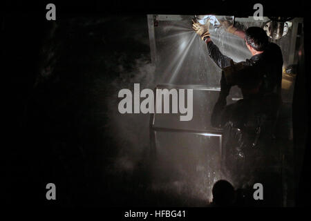 Ein Midshipman der U.S. Naval Academy nimmt an einer Übung zur Schadenskontrolle im Submarine Learning Center Detachment San Diego Teil, bei der das Patchen von Lecks als Teil der Entwicklung von Fähigkeiten im U-Boot- und Oberflächenkrieg, einschließlich Taktik, nukleare Operationen, Teamkoordination und Umgang mit Depot-Waffen, praktiziert wird. Stockfoto