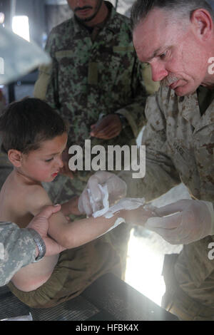 110104-M-5112P-071 SANGIN Tal, Afghanistan (4. Januar 2011) Lt. CMdR Patrick M. Hare, ein Amtsarzt zugewiesen, das 3. Bataillon, 5. Marineregiment gilt brennen Salbe zu einem afghanischen Kind während einer Gesundheitsinitiative in Sangin, Afghanistan. Die Initiative wird durchgeführt, um lokale Anbieter von Gesundheitsleistungen zu trainieren, Behandlung von Kranken und Verletzten und afghanischen nationalen Sicherheitskräfte Beziehungen im Bereich verstärken. Das Bataillon führt Aufstandsbekämpfung Operationen mit der International Security Assistance Force und Regimental Combat Team 2 zugeordnet ist. (U.S. Marine Corps Foto von Lance Cpl. Jos Stockfoto