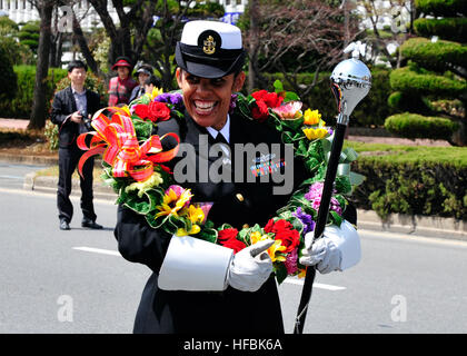 110409-N-RO948-012 CHANGWON, Südkorea (9. April 2011) Chief Musiker Lucliada Barbosa versucht auf einem Blumen-Kranz von Parade Beamten gegeben wie in den USA 7. Flotte Band bereitet bis März in einer street Parade 2011 Jinhae International Military Band und Honor Guard Festival. Die Band ist mit neun anderen internationalen Militärkapellen während der dreitägigen Veranstaltung, Durchführung alle zwei Jahre stattfindet. (Foto: U.S. Navy Mass Communication Specialist 2. Klasse Dustin Kelling/freigegeben) - offizielle US Navy Bilder - Navy Musiker trägt Blumen Kranz Parade Changwon, Korea Stockfoto