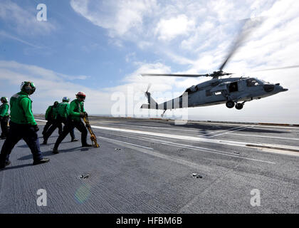 Pazifik (5. Oktober 2012) Segler stemmen sich wie ein MH-60R Sea Hawk Hubschrauber vom Hubschrauber Meer bekämpfen Squadron (HSC) 6 aus dem Flugdeck des Flugzeugträgers USS Nimitz (CVN-68 zieht) Flugzeug Wache Verantwortung im Flugbetrieb. Nimitz führt derzeit laufenden Flotte Ersatz Schwadron Träger Qualifikationen. Der US-Marine ist zuverlässig, flexibel und bereit, auf, über und unter dem Meeresspiegel weltweit zu reagieren. Nehmen Sie das Gespräch in den sozialen Medien mit #warfighting. (Foto: U.S. Navy Mass Communication Specialist 3. Klasse Ryan J. Mayes/freigegeben) Stockfoto