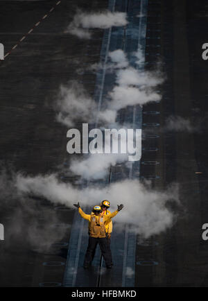 Luftfahrzeugpersonal an Bord der USS Carl Vinson (CVN 70) führen ein Starrflügelflugzeug auf Bugkatapulte, während es am 20. Februar 2011 mit der Carrier Strike Group eingesetzt wurde, um die maritimen Sicherheitsoperationen und die Zusammenarbeit im Bereich der Theatersicherheit im Gebiet der 5. US-Flotte zu unterstützen. Stockfoto