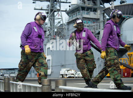 PHILIPPINENSEE (20. September 2012) Luftfahrt Bootsmann Mates (Kraftstoff) bewegen, Kraftstoffschlauch über das Flugdeck an Bord der amphibischen Angriff Schiff USS Bonhomme Richard (LHD-6) im Flugbetrieb. (Foto: U.S. Navy Mass Communication Specialist 2. Klasse Michael Russell/freigegeben) 120920-N-KB563-160 verbinden das Gespräch www.facebook.com/USNavy www.twitter.com/USNavy navylive.dodlive.mil - offizielle US Navy Bilder - Segler bewegen Kraftstoffschlauch. Stockfoto